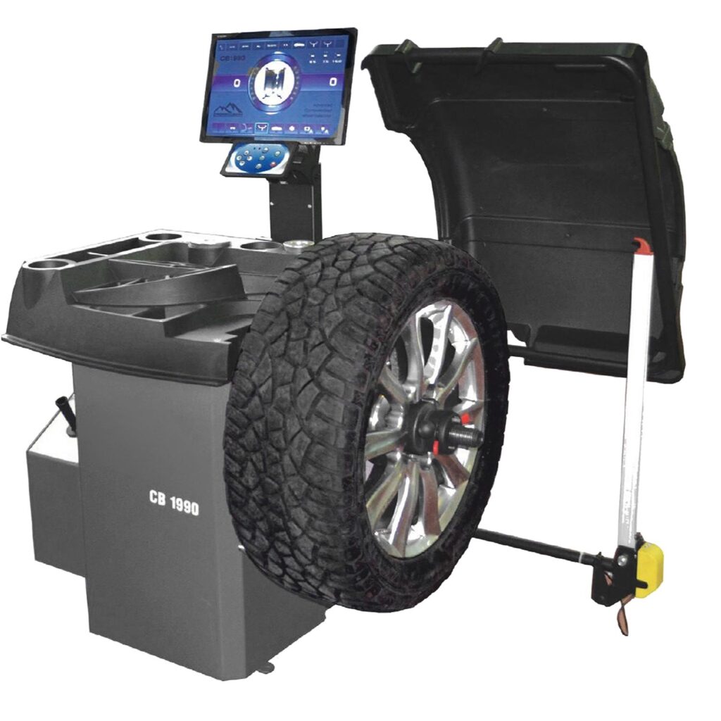 Radauswuchtmaschine mit montiertem Offroad-Reifen, geöffnetem Schutzdeckel und großem Touchscreen-Bedienmonitor zur präzisen computergestützten Auswuchtung.