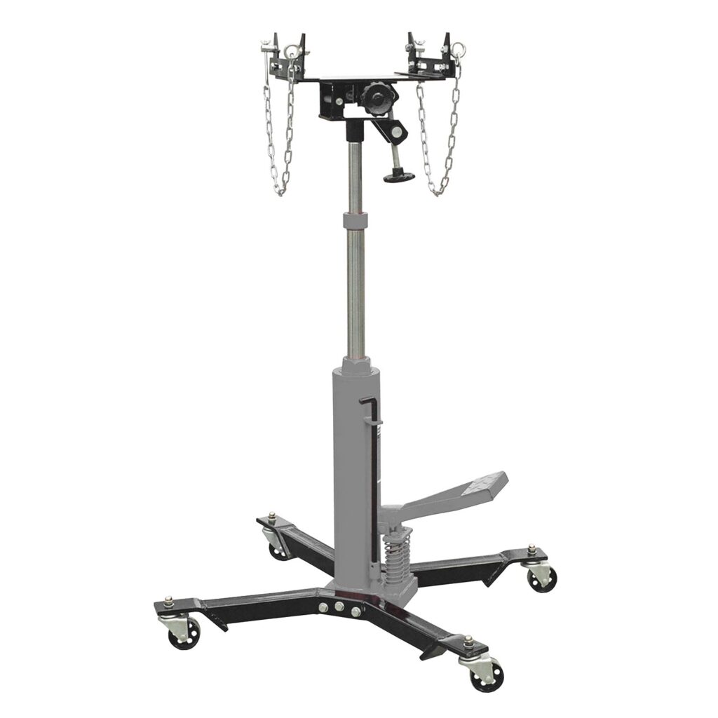 Hydraulischer Getriebeheber von TB Gradient mit höhenverstellbarer Hubspindel, kipp- und drehbarer Aufnahmeeinheit inklusive Sicherungsketten, Fußpedal für präzises Anheben sowie stabilem Fahrgestell mit vier Lenkrollen für den flexiblen Einsatz in der Werkstatt.