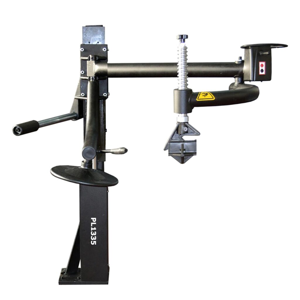 Schwarzer, vertikal montierter Fahrzeuglift mit horizontalem Ausleger, höhenverstellbarer Schraubaufnahme, Handkurbel, Fußauflage und Warnsymbol, freigestellt auf weißem Hintergrund.