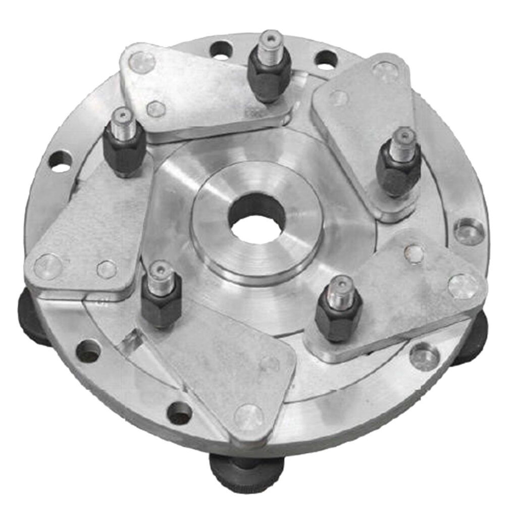 Runde mechanische Spann- und Zentriereinheit aus massivem Aluminium mit zentraler Durchgangsbohrung, mehreren radial angeordneten Spannarmen und justierbaren Bolzen zur präzisen Fixierung von Bauteilen auf rotierenden Maschinen.